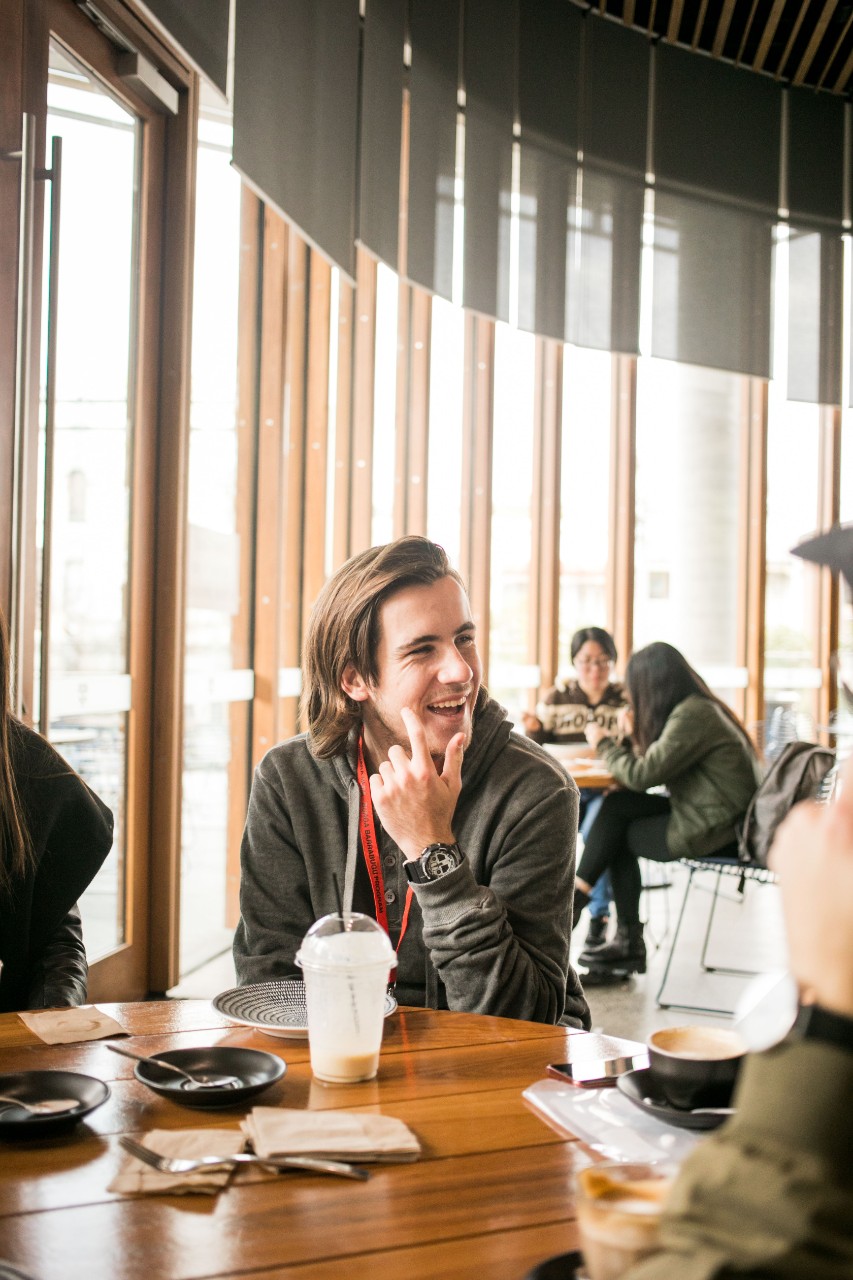 A photo of a young Aboriginal man sitting in a cafe.