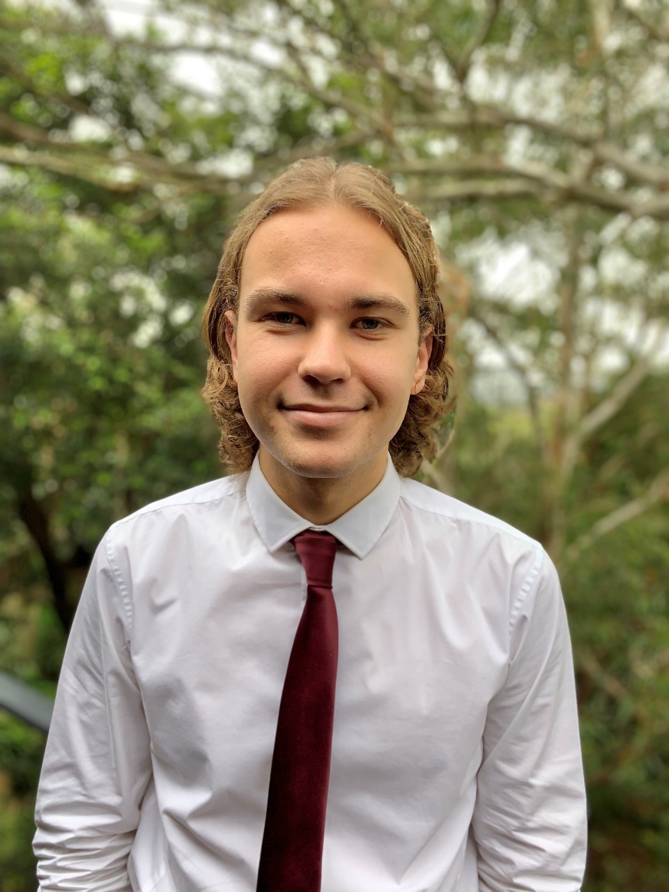 Picture of Josh Glass in a white button up and maroon tie