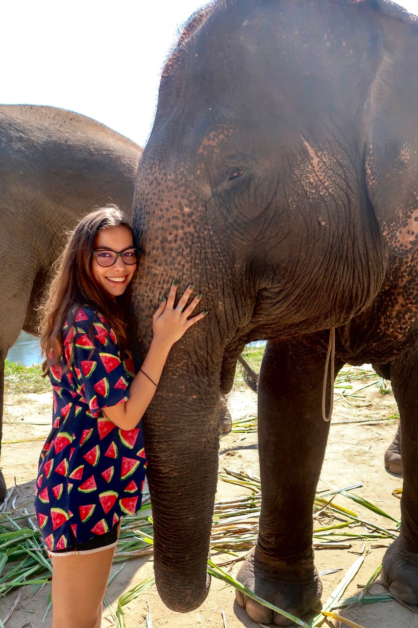 Hannah hugging an elephant while smiling