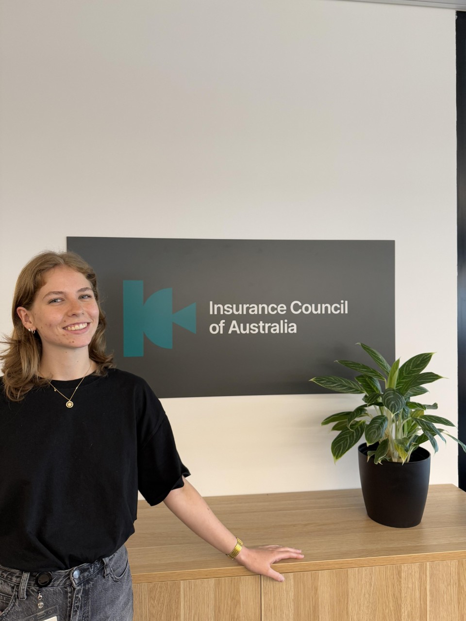Larissa Venhorst in front of a sign with the Insurance Council of Australia logo.