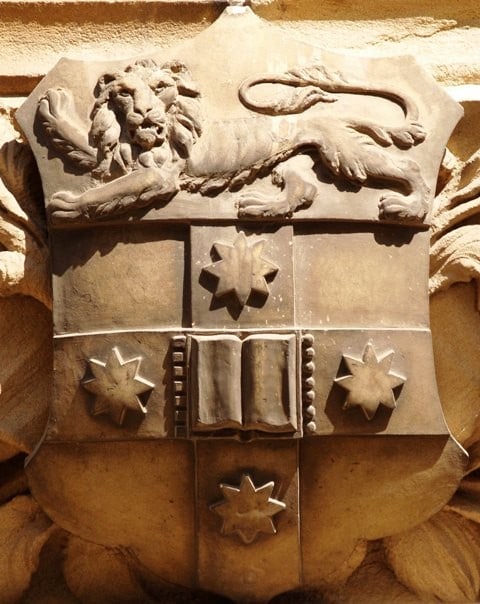 Carved arms in sandstone over the Clocktower entrance to the University's Quadrangle.