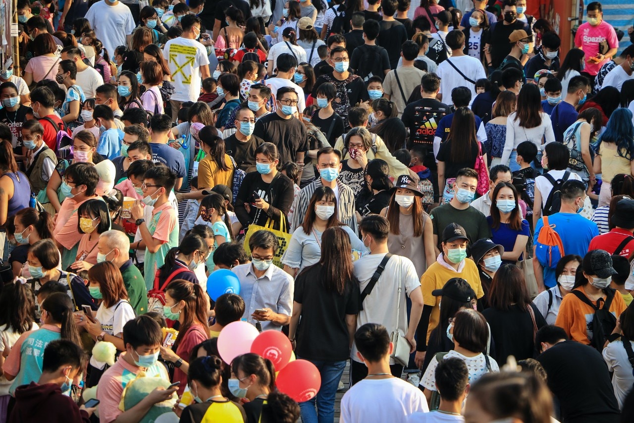 A crowd of people wearing surgical masks