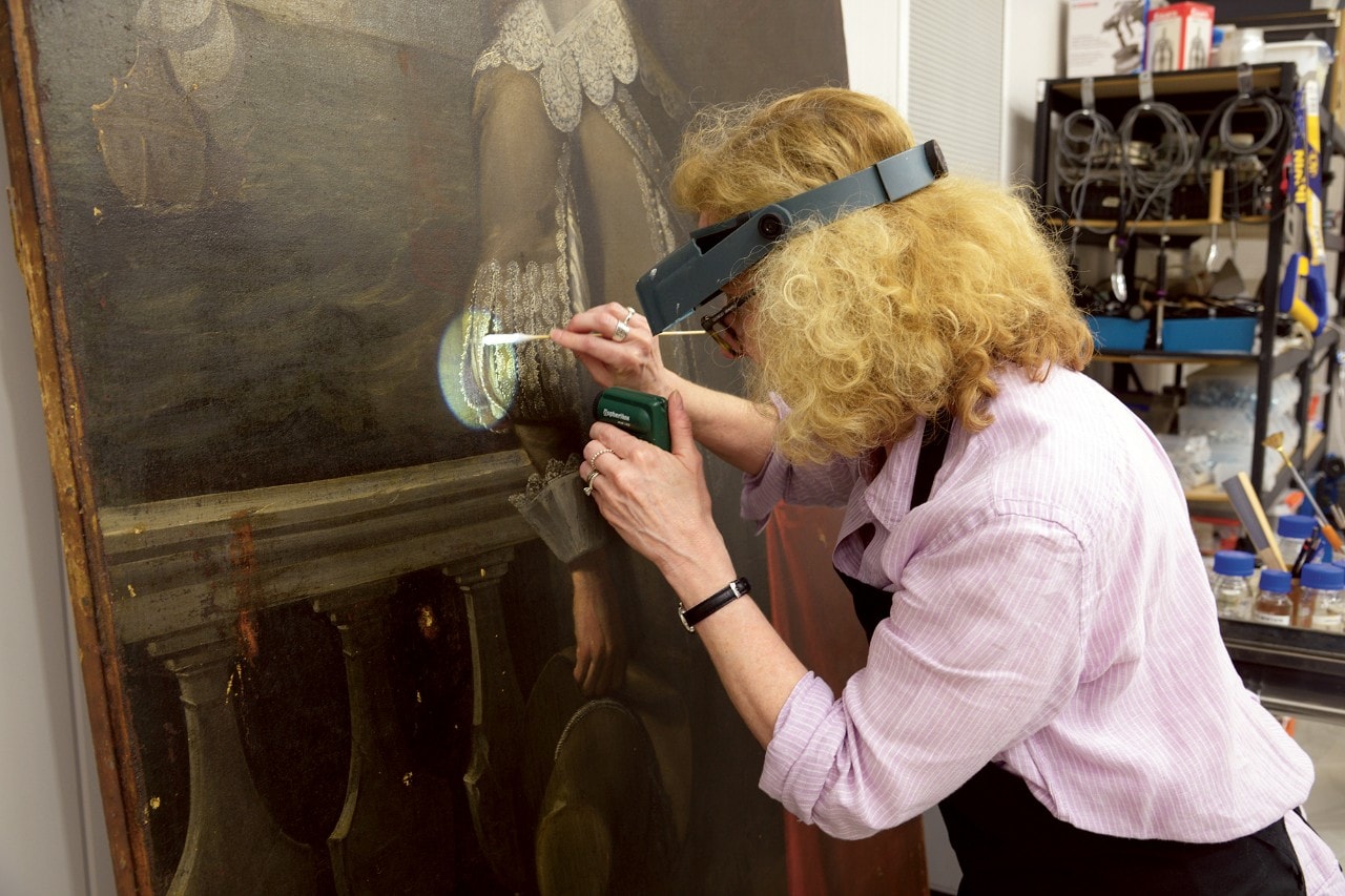 Woman wearing headlamp working on painting