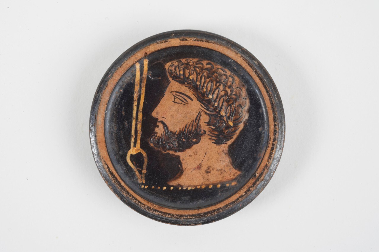 Pot with lid viewed from above featuring the head of Hephaistos
