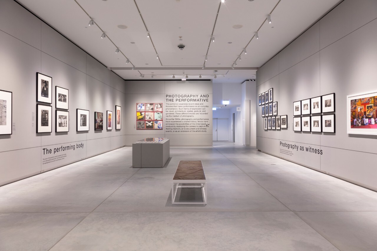 Art gallery with grey walls, concrete floor, framed photographs hung on the walls