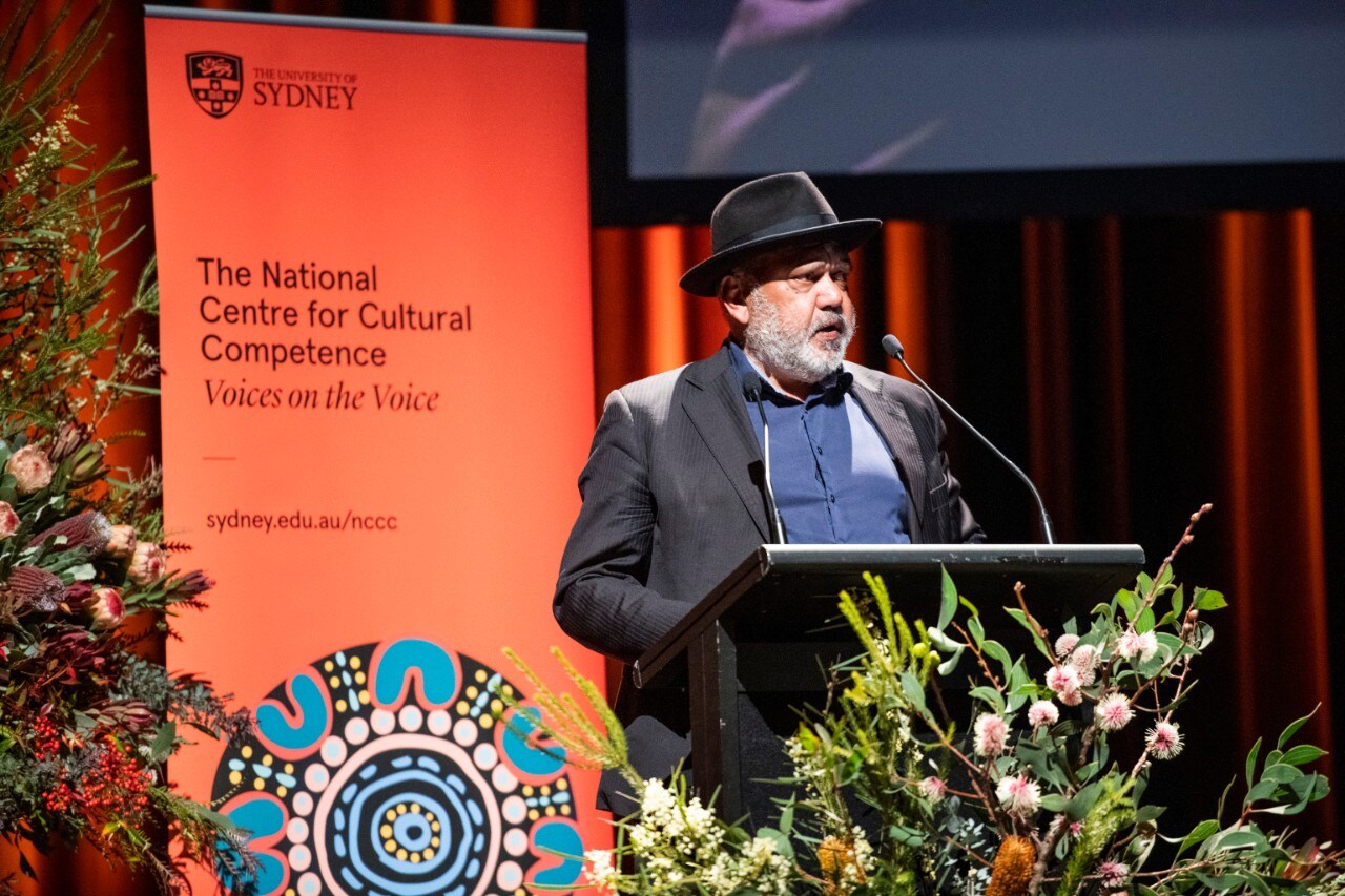 Noel Pearson at lectern with National Centre for Cultural Competence banner behind him