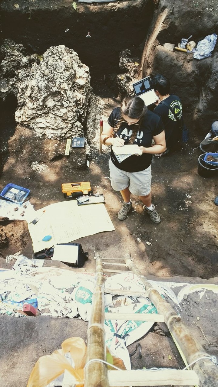 Dr Melandri Vlok standing deep in a hole surrounded by tools