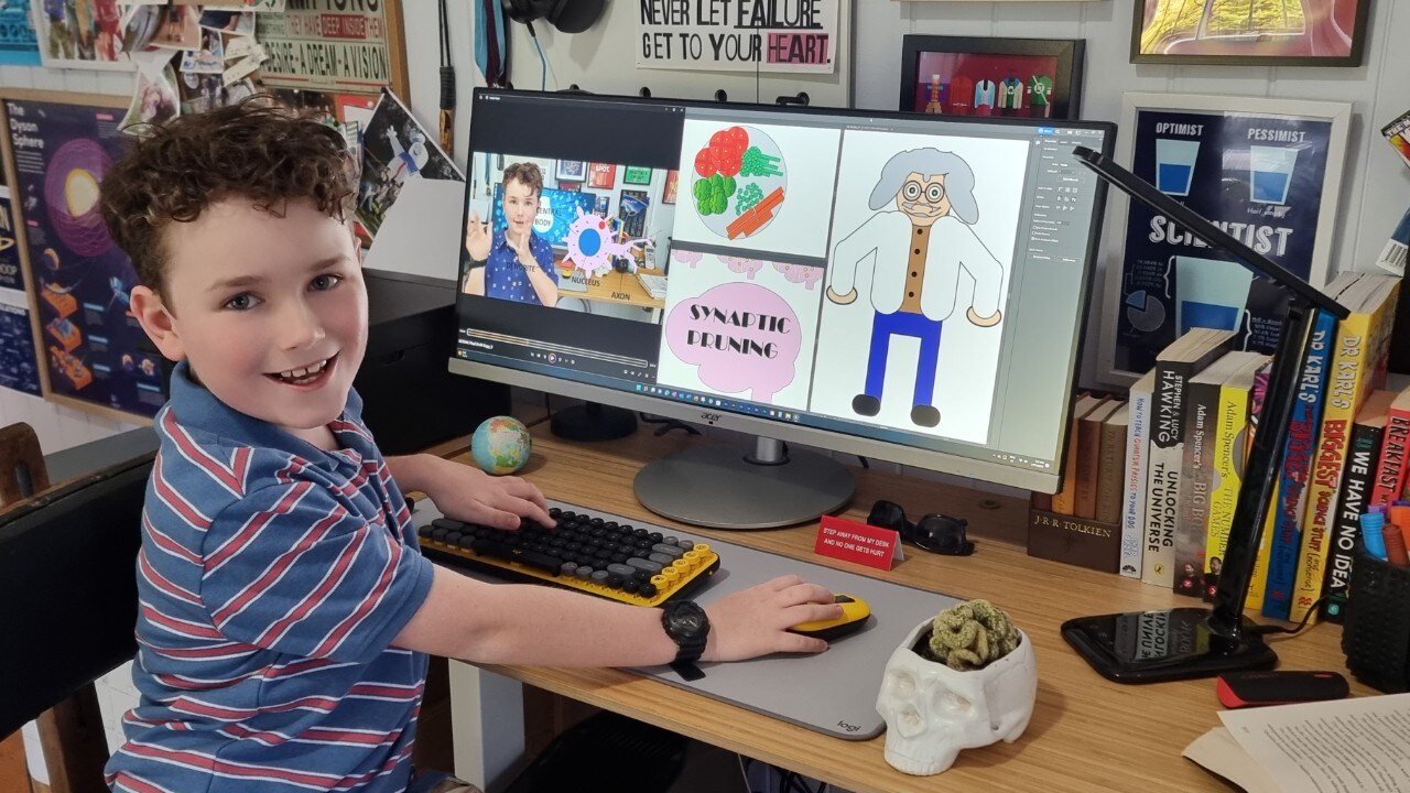 A boy using a computer, turning and smiling