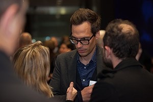 Image of three people conversing in a crowded place