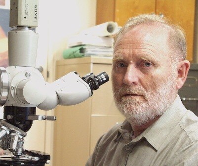 Photo of Dr John Walker with a microscope