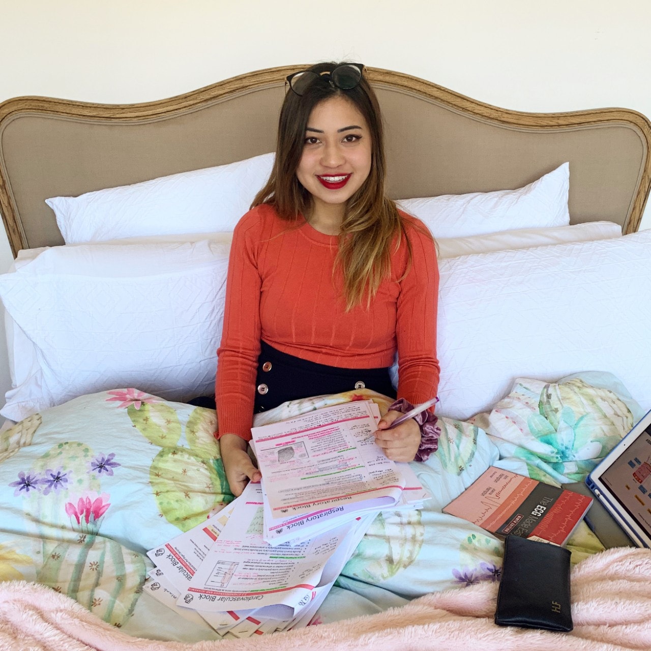 Student studying from home in her bed.