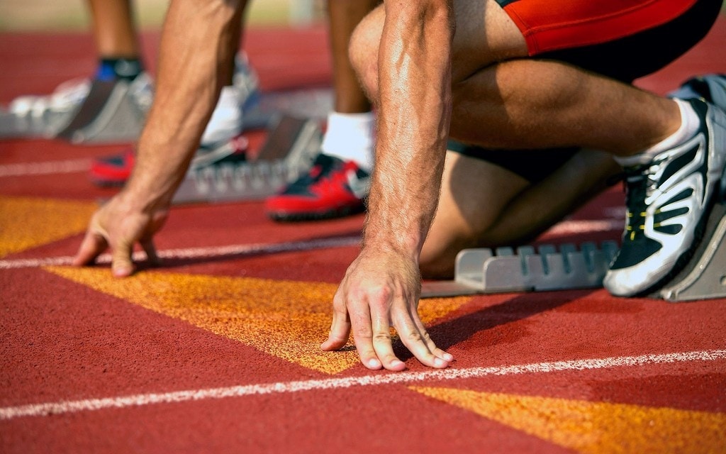 A runner crouches on a track, ready to begin a race.