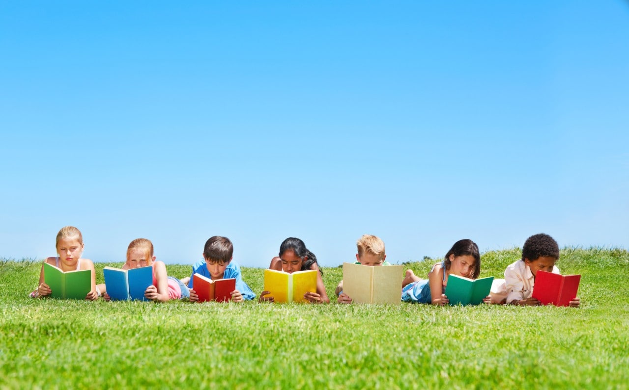 A group of children reading in the park. Image: iStock
