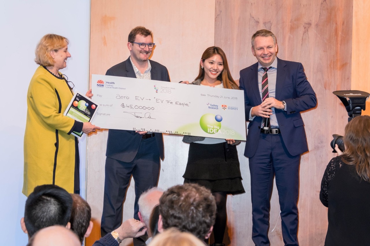 Associate Professor Wojciech Chrzanowski (right) and Sally Kim (second from right) receive the winner's cheque from Sydney Health.