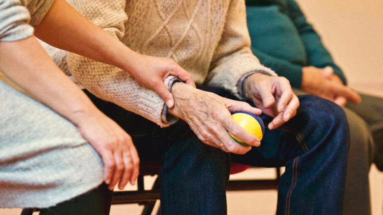 Stock image of an aged care worker helping elderly man. 