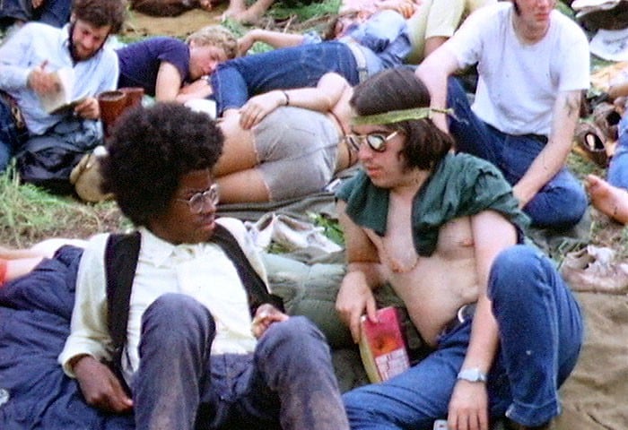 Two young men sitting on the grass at Woodstock Music Festival, August 1969