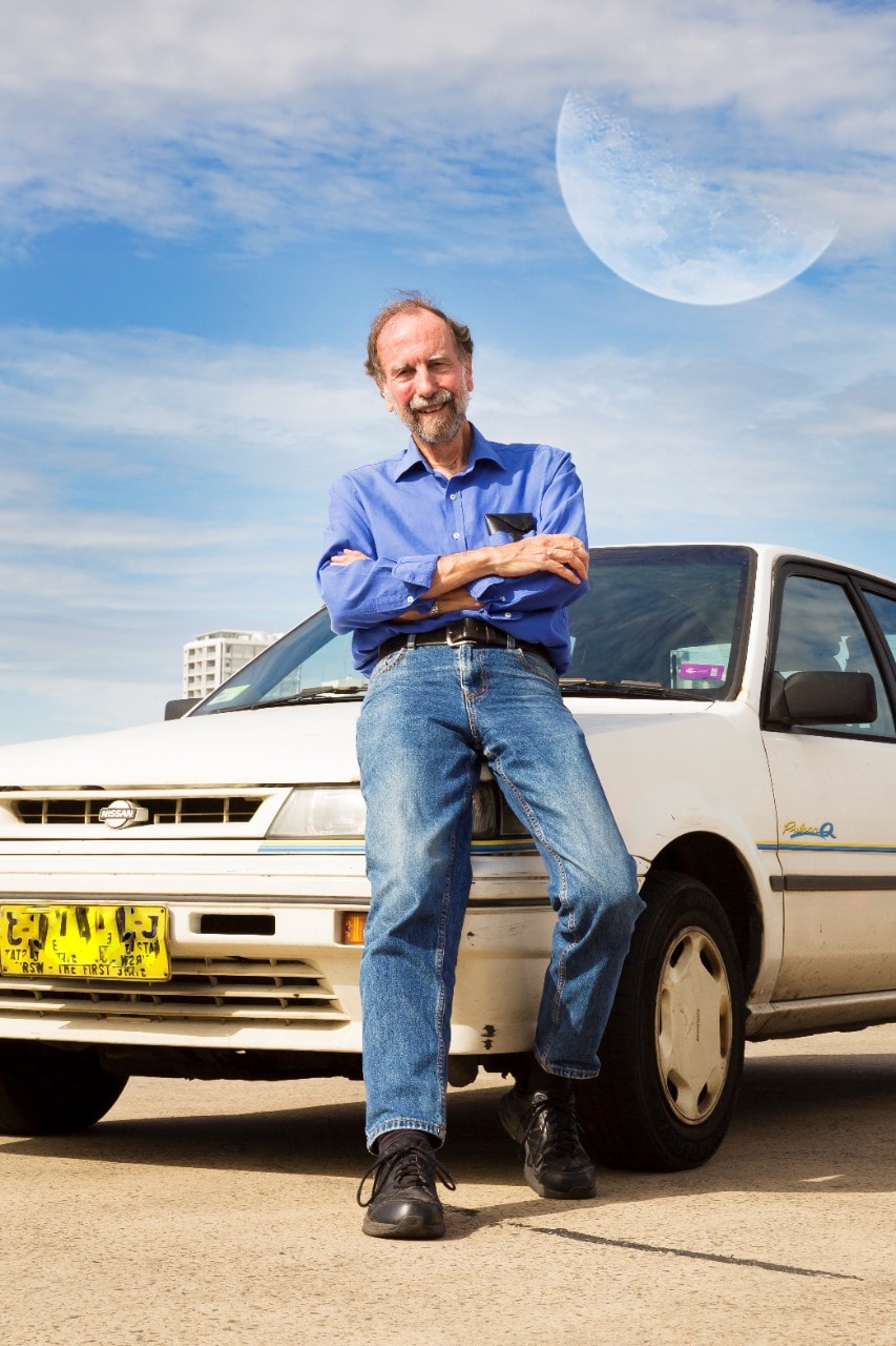 Portrait of Hunstead with his car, which he loves because it has driven the distance to the moon and back.