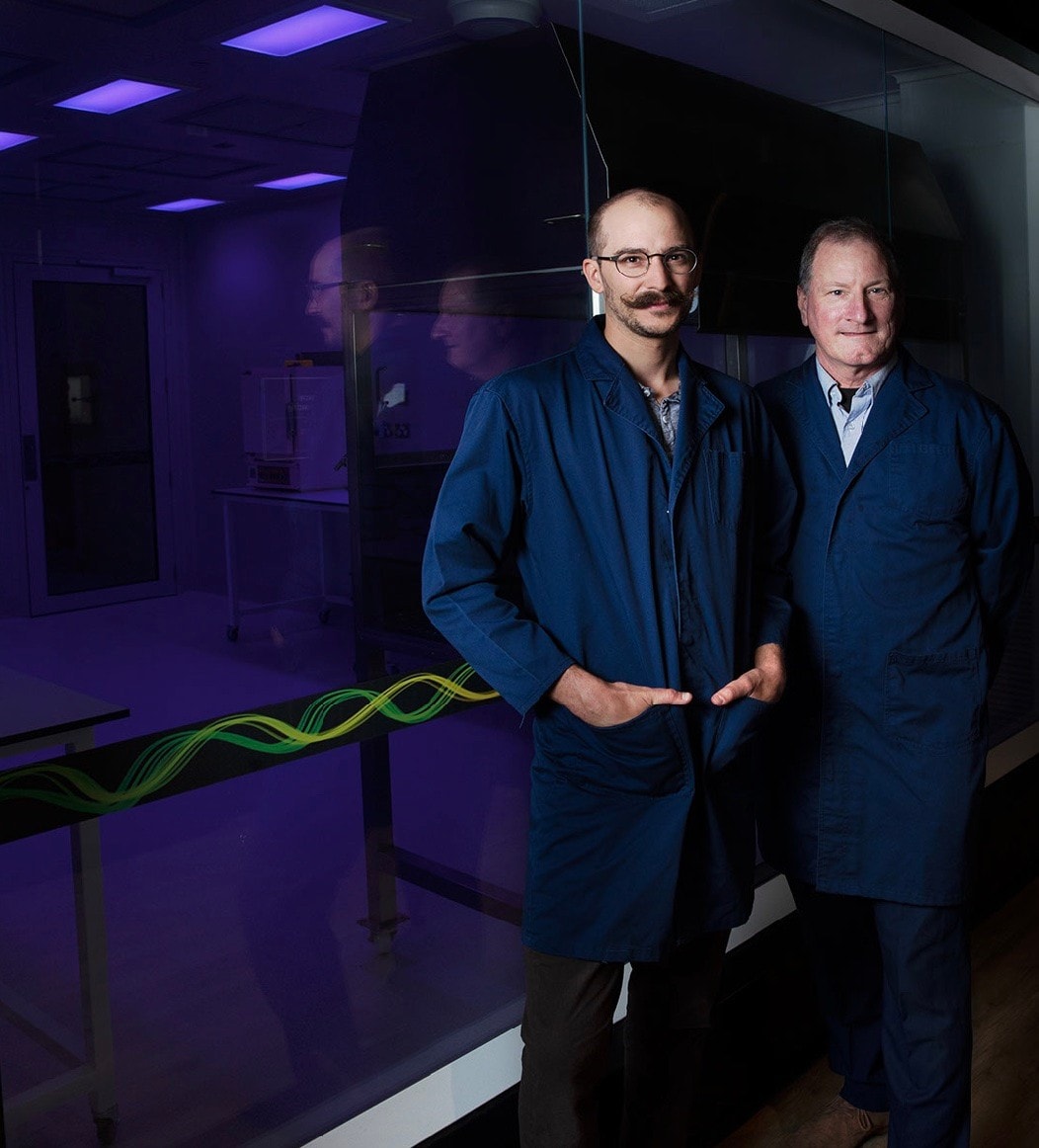 photo of the two researchers in lab coats Mr Samuel  Eggenbergerand Professor Gregg Suaning