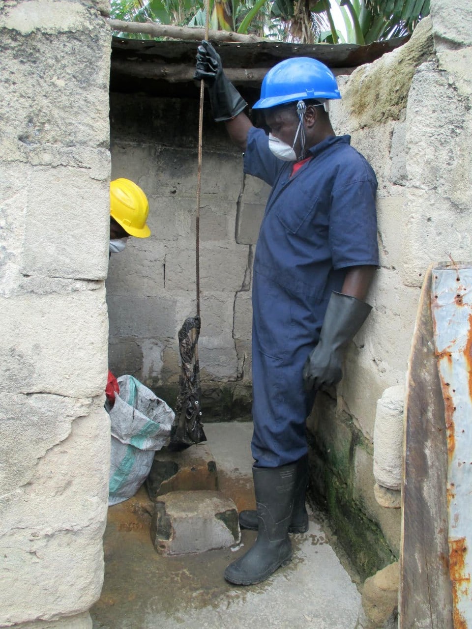 A man empties a pit latrine in urban Tanzania
