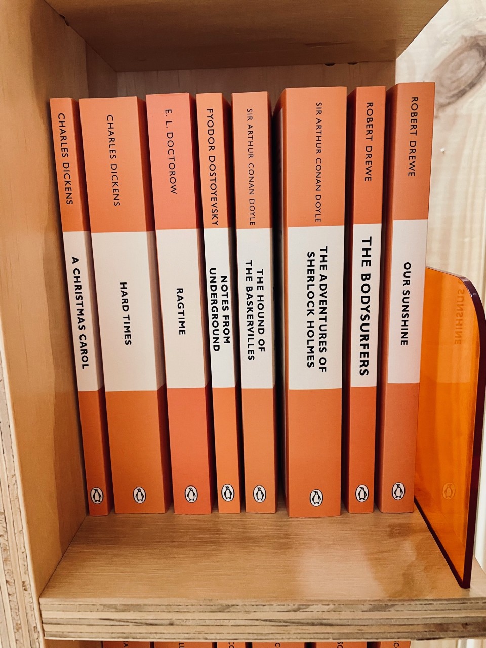 orange Penguin classic books on a book shelf in a shop