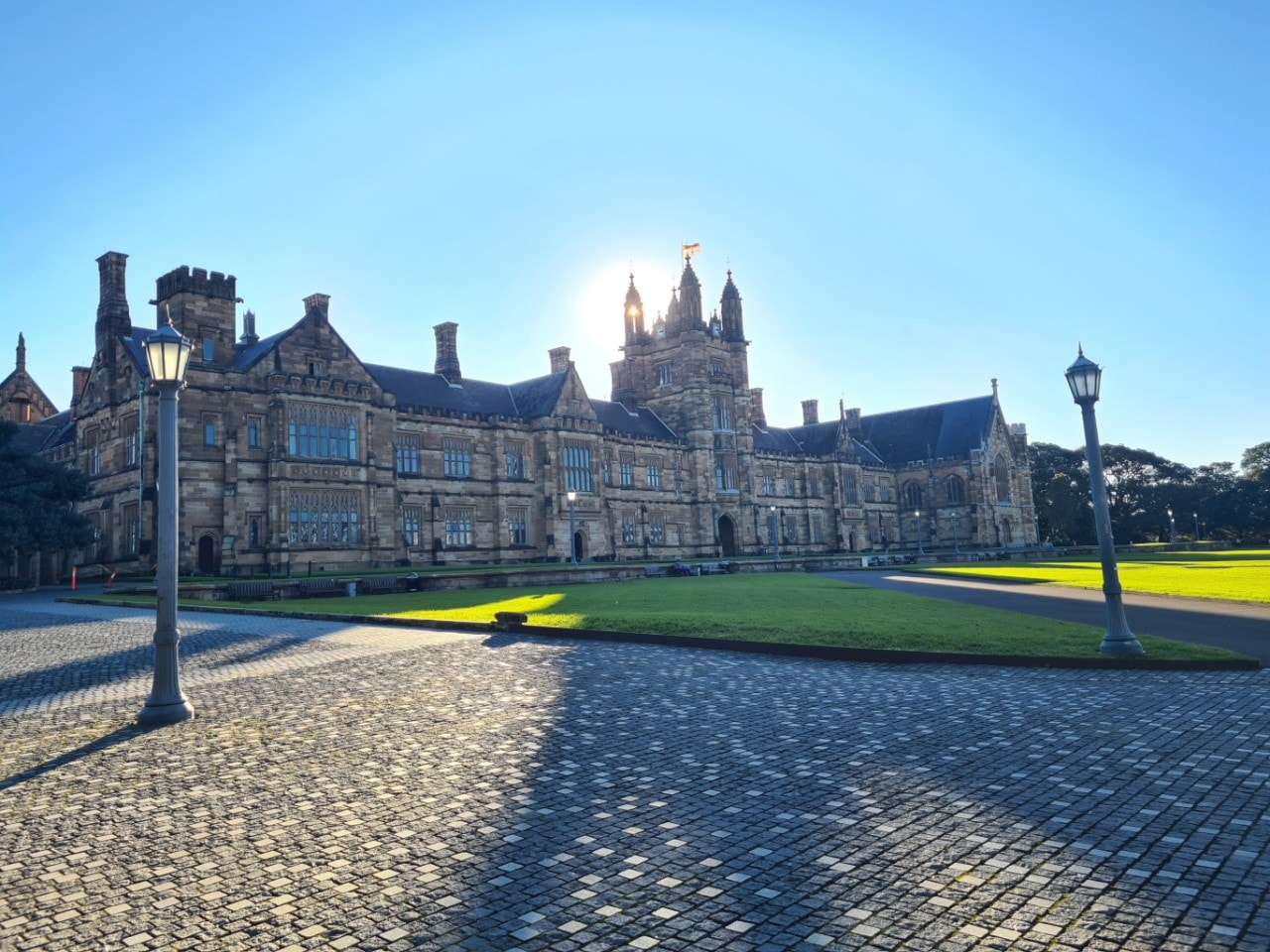 The University of Sydney's sandstone Quadrangle, with the sun shining behind (photo credit Joel Murray)