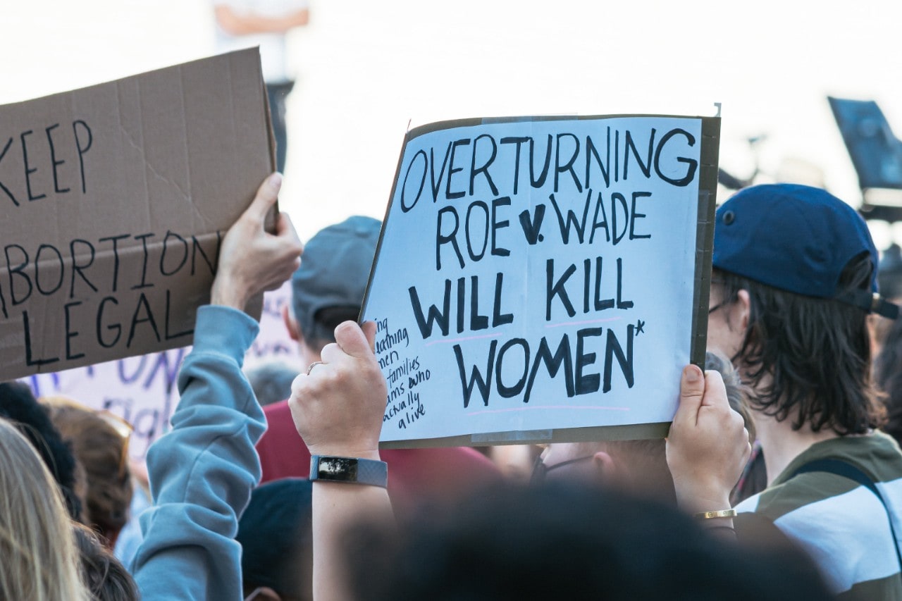 roe-v-wade-protest with people holding up signs that say "overturning Roe v Wade will kill women"