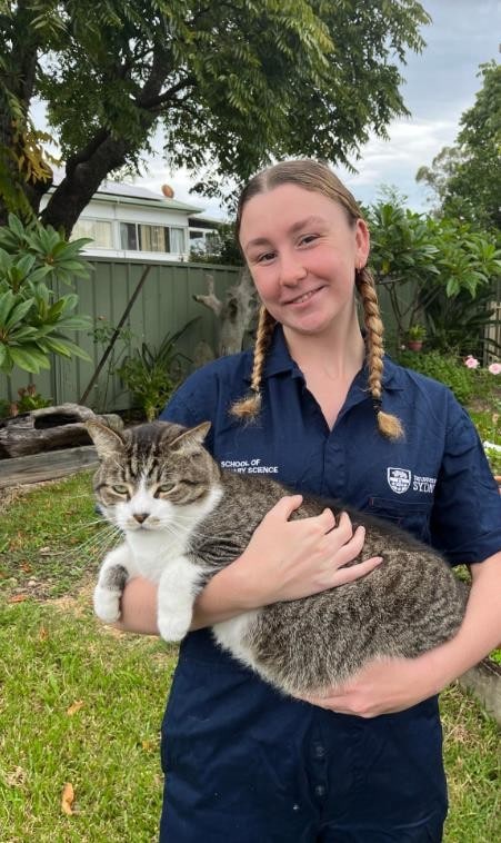 Brianna wearing a University of Sydney Vet School shirt holding a cat