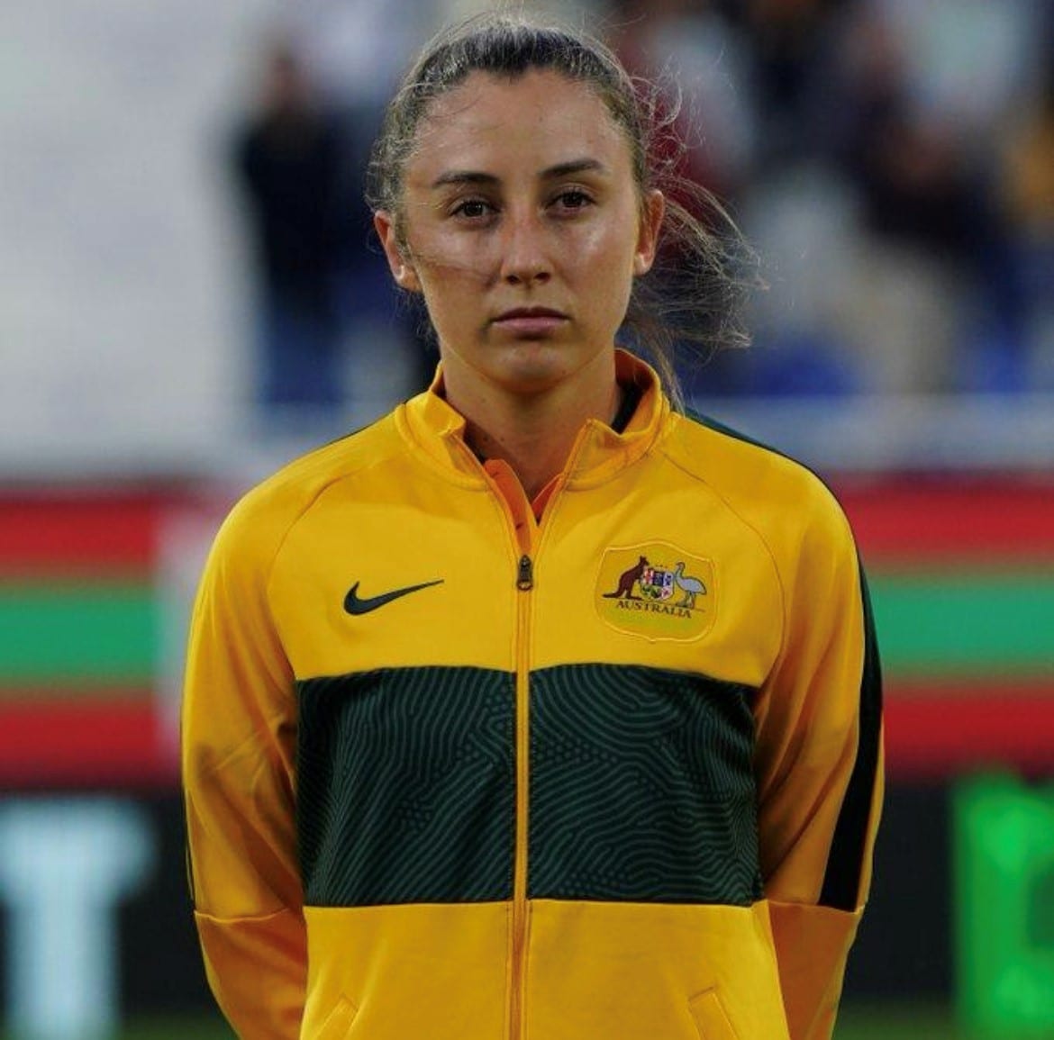Clare Wheeler in green and yellow Matildas uniform waiting to play