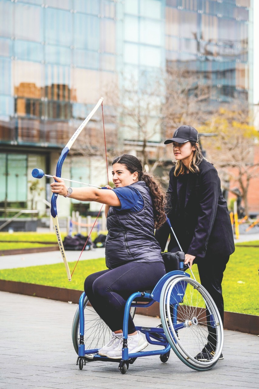 Participants try wheelchair archery on Eastern Avenue during 2022 Disability Inclusion Week