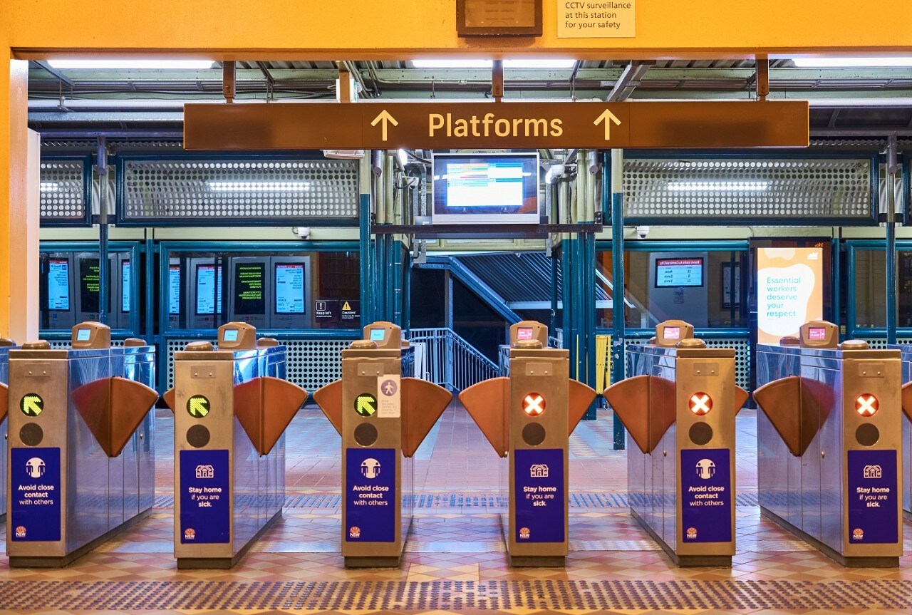 Access gates at a Sydney train station, with a train visible in the background