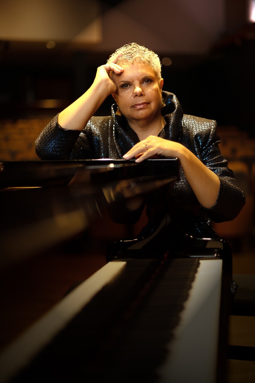 Deborah Cheetham Fraillon sitting at the piano smiling at Sydney Conservatorium of Music