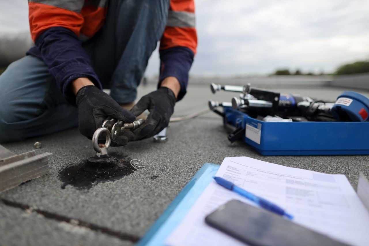A man checks attachment cables on a job site