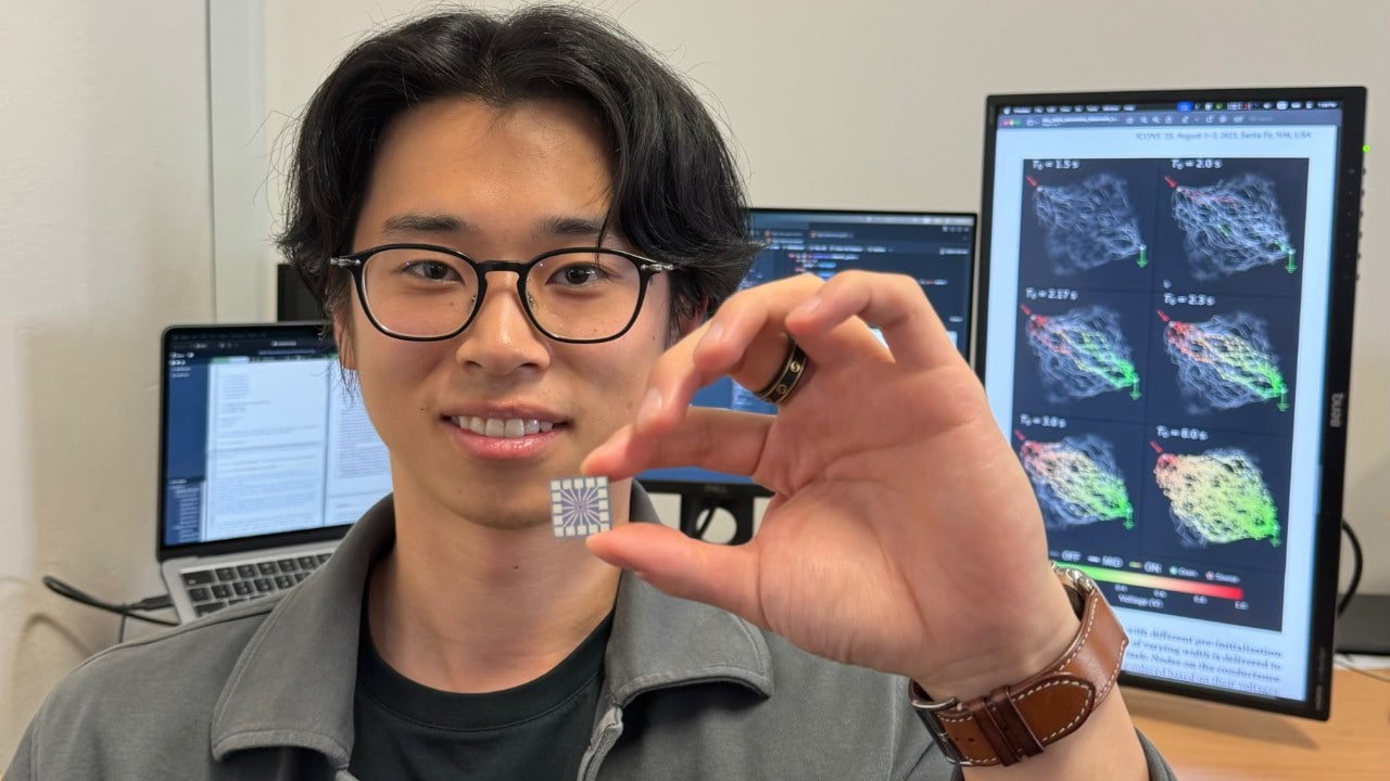 Lead author and PhD student Ruomin Zhu holding the chip that manages the neural network at its centre.