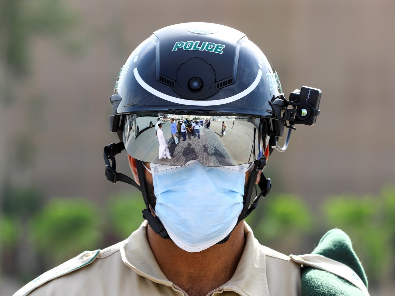 A policeman wearing a 'smart' helmet that can detect people's temperatures.