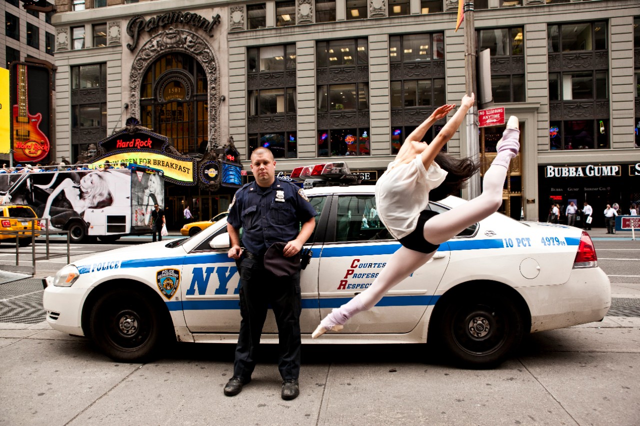 An NYPD police officer standing next to a ballet dancer