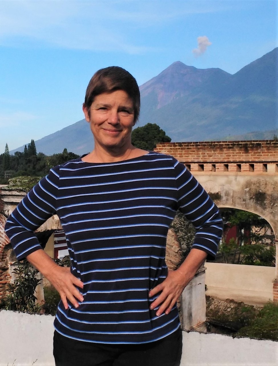 Rebecca Peters standing in front of a volcano in Guatemala