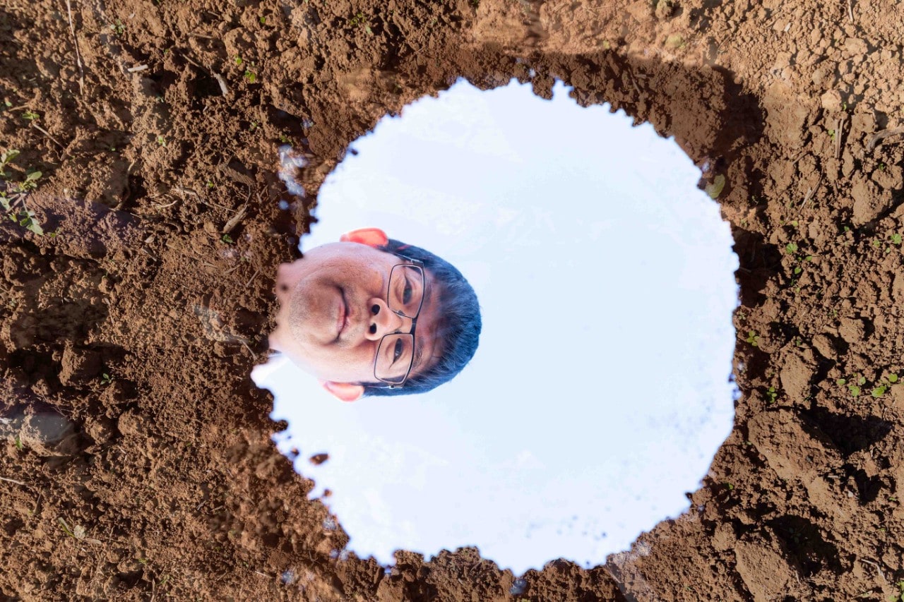 Budiman Minasny looking in a puddle 