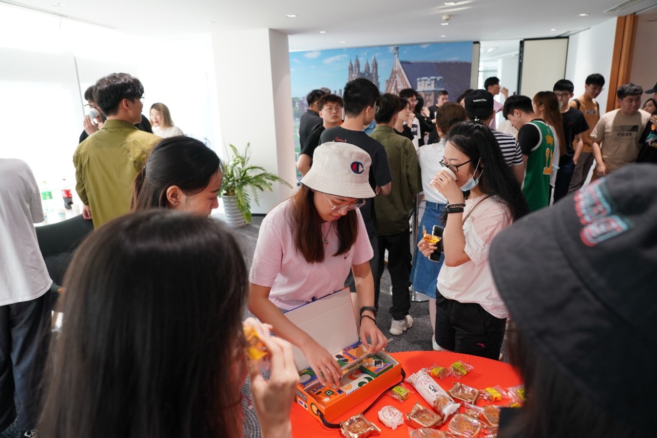 Chinese students gather around a table full of mooncakes