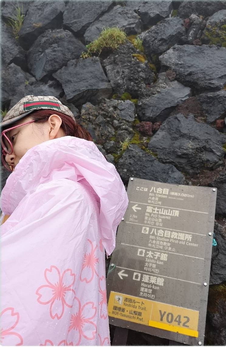 Waner Zhengguan wearing a raincoat as she climbs Mt Fuji