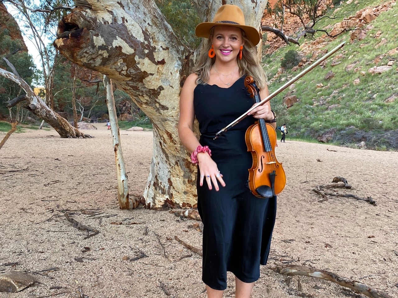 Female with violin in the outback