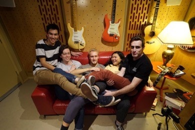 Student band sitting on the lounge in front of guitars