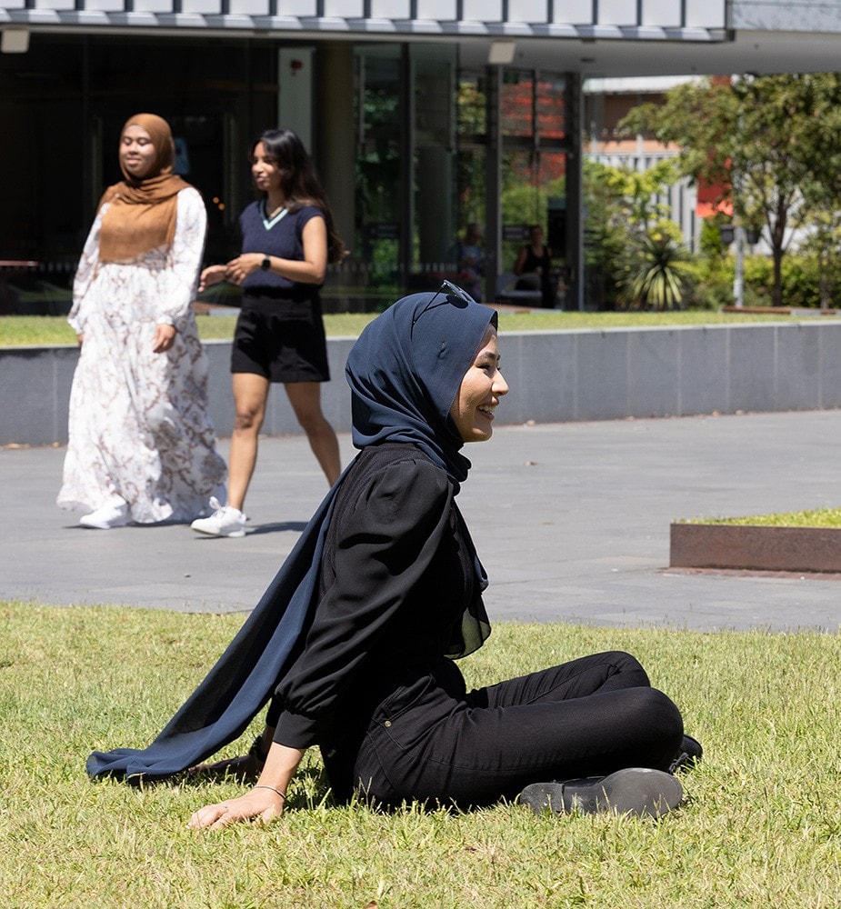 Naz Sharifi sits outside the Sydney Law School