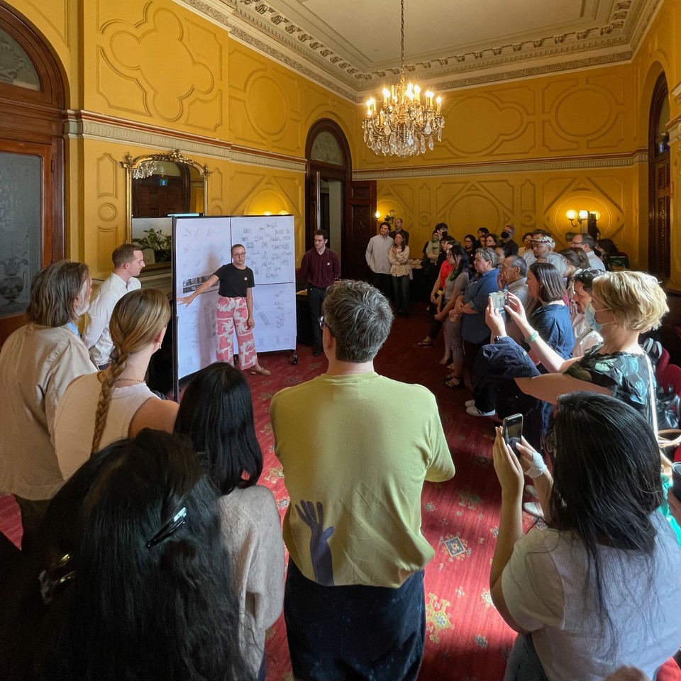 A student presenting their work to a room of stakeholders at Sydney Town Hall